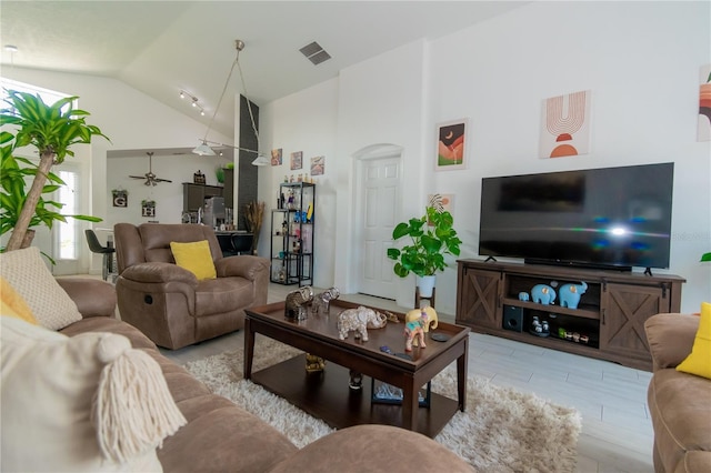 living room with visible vents, plenty of natural light, and high vaulted ceiling