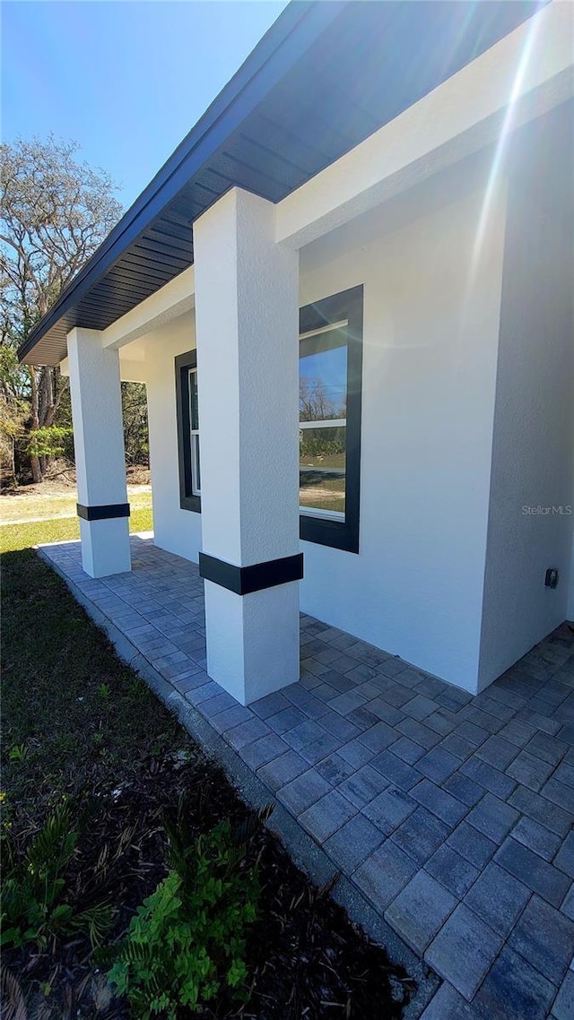 view of property exterior with stucco siding and a patio area