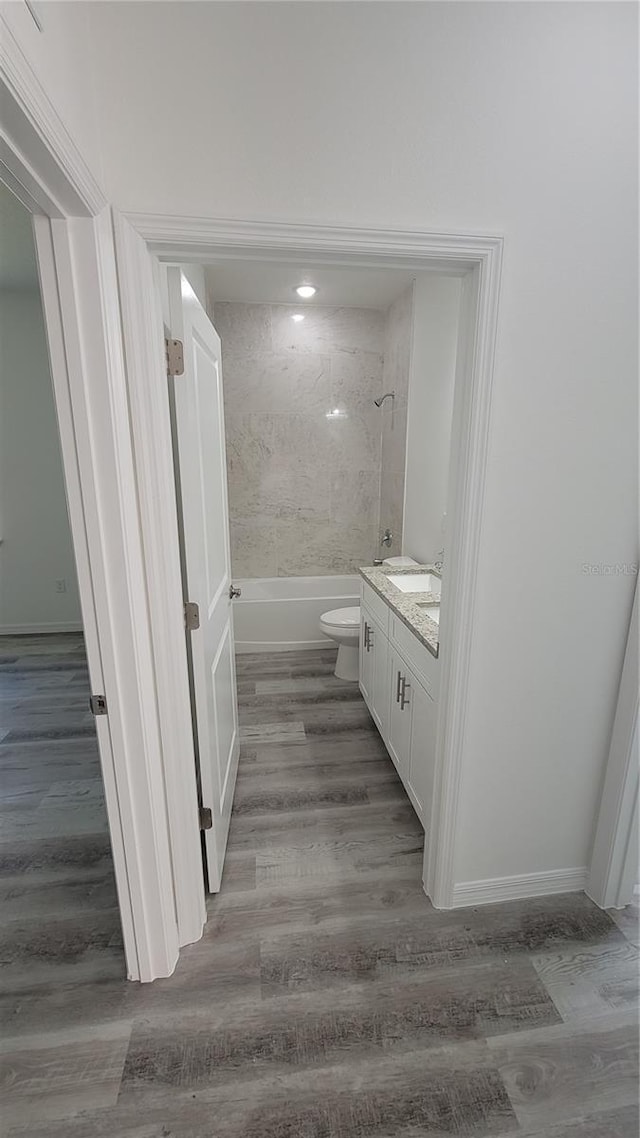 full bathroom featuring tub / shower combination, toilet, wood finished floors, and vanity