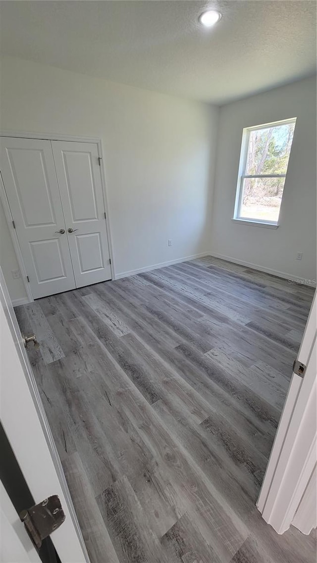 unfurnished room with baseboards and wood finished floors