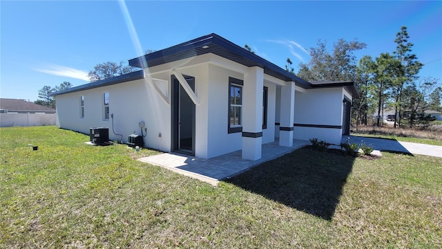 view of property exterior with cooling unit, a lawn, and stucco siding