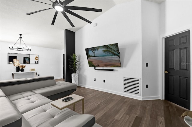 living area featuring wood finished floors, visible vents, baseboards, high vaulted ceiling, and a notable chandelier