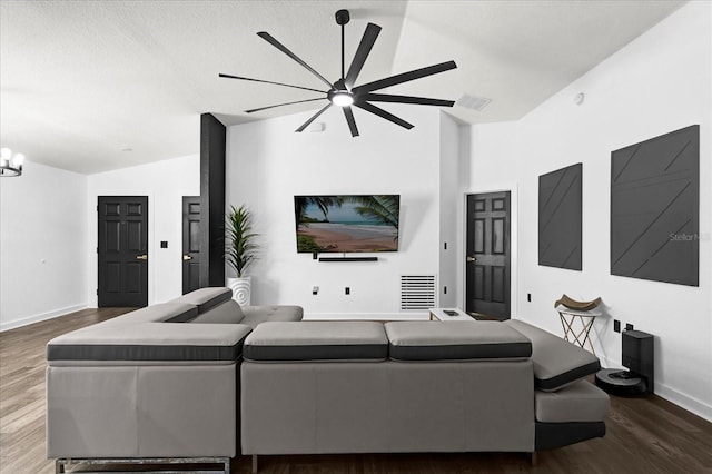 living area featuring a notable chandelier, visible vents, baseboards, and wood finished floors