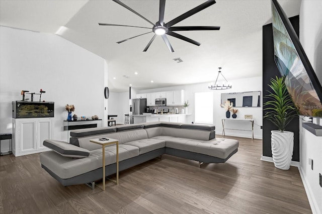 living area featuring visible vents, dark wood finished floors, recessed lighting, vaulted ceiling, and ceiling fan with notable chandelier