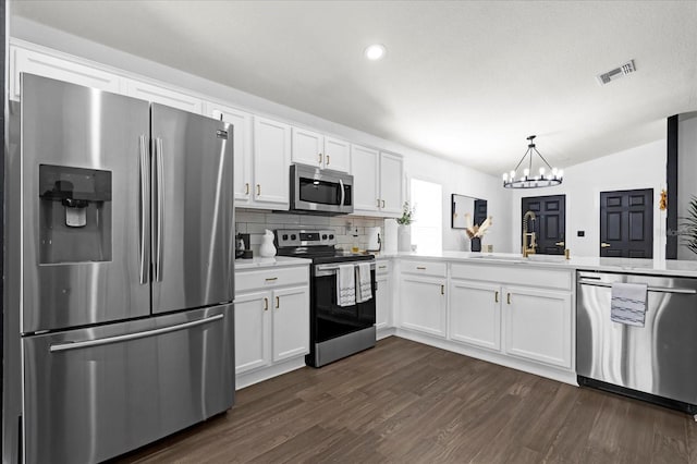 kitchen featuring visible vents, dark wood finished floors, appliances with stainless steel finishes, white cabinets, and a sink