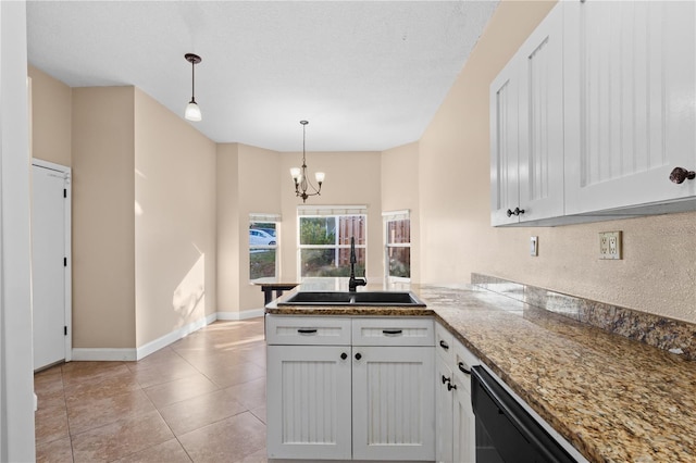 kitchen with a peninsula, light tile patterned flooring, a sink, pendant lighting, and dishwasher