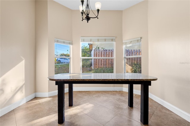 unfurnished office with tile patterned flooring, baseboards, and an inviting chandelier