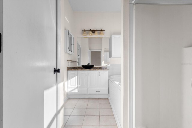 full bath featuring vanity, tile patterned floors, and a garden tub