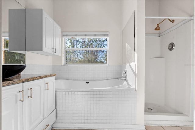 bathroom featuring vanity, a garden tub, and a stall shower