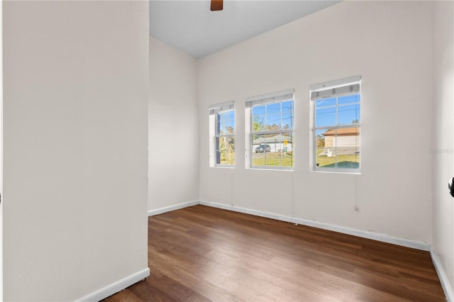 unfurnished room with ceiling fan, baseboards, and wood finished floors