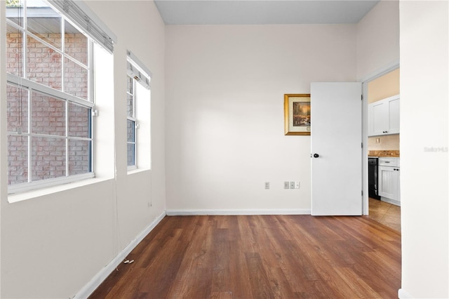 spare room with wood finished floors and baseboards