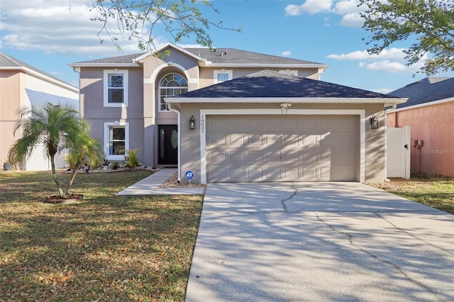 traditional-style house featuring driveway, an attached garage, a shingled roof, stucco siding, and a front lawn