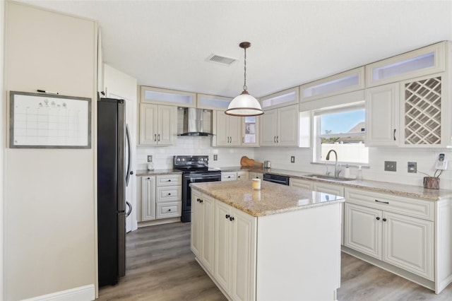 kitchen with visible vents, a sink, decorative backsplash, black appliances, and wall chimney exhaust hood