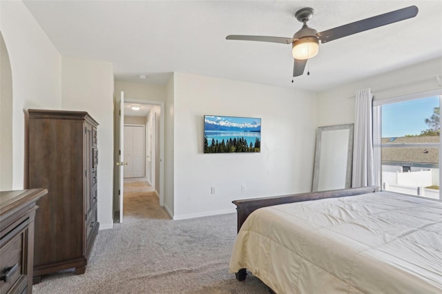 bedroom featuring light colored carpet, baseboards, and ceiling fan