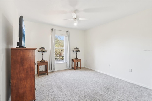 interior space featuring baseboards, a ceiling fan, and carpet flooring