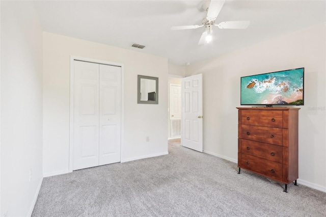 unfurnished bedroom featuring visible vents, light carpet, a ceiling fan, a closet, and baseboards