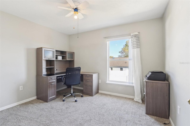 office with baseboards, light colored carpet, and a ceiling fan