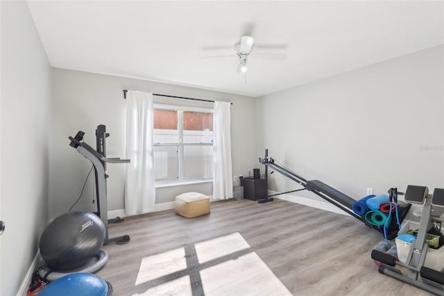 workout area with ceiling fan, baseboards, and wood finished floors