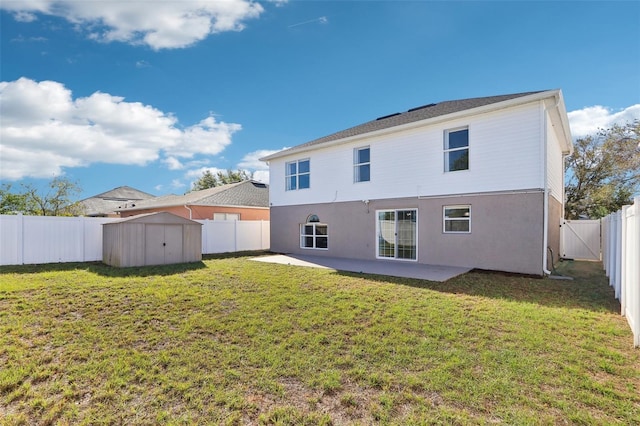 back of house with a fenced backyard, stucco siding, an outdoor structure, a storage unit, and a lawn