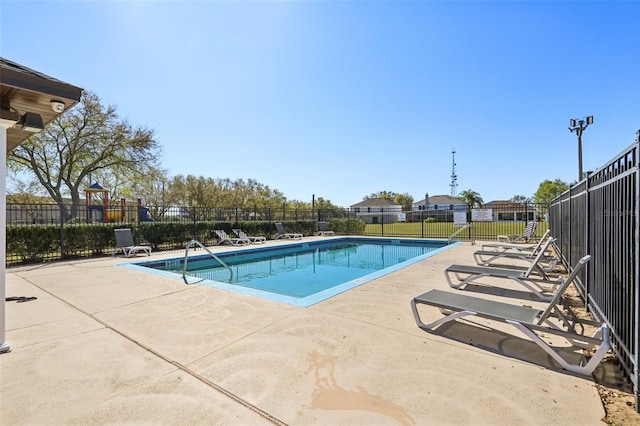 pool with a patio area and fence