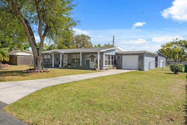 single story home featuring concrete driveway, an attached garage, fence, and a front lawn