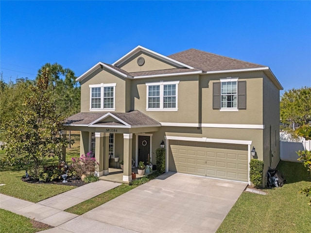 view of front of property with stucco siding, an attached garage, concrete driveway, and a front lawn