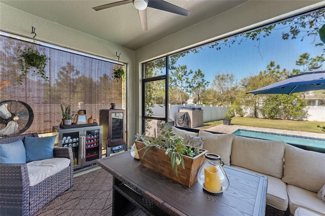 sunroom featuring beverage cooler and a ceiling fan