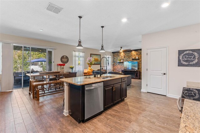 kitchen with visible vents, open floor plan, appliances with stainless steel finishes, light wood-style floors, and a sink