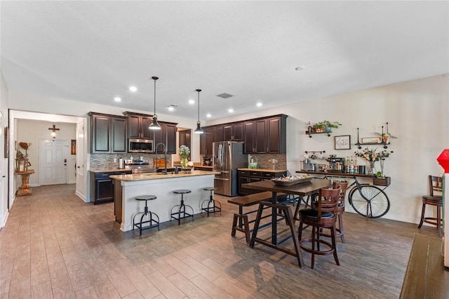 kitchen featuring stainless steel appliances, dark wood-type flooring, and decorative backsplash