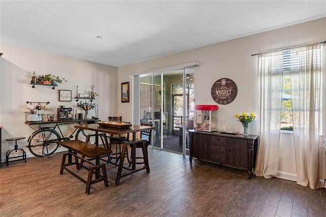 dining area with dark wood-style floors and a textured ceiling