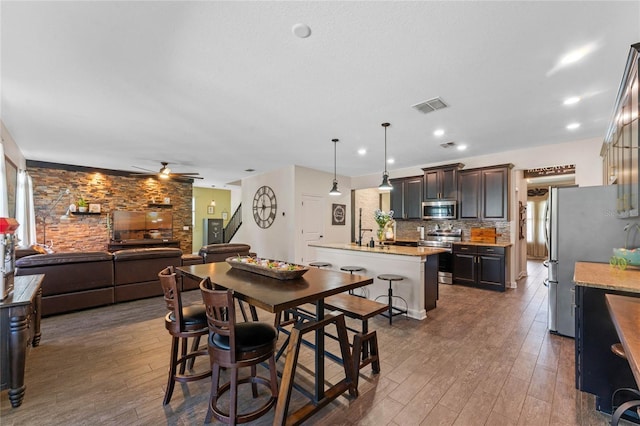 dining room featuring a ceiling fan, dark wood-style floors, and visible vents