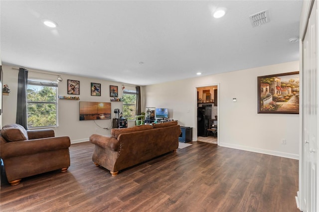 living room featuring dark wood finished floors, a healthy amount of sunlight, and visible vents