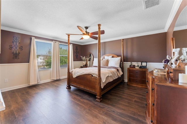 bedroom featuring dark wood finished floors, visible vents, a textured ceiling, and ornamental molding