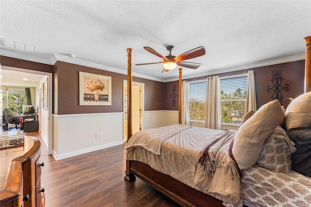 bedroom featuring a textured ceiling, dark wood-type flooring, ceiling fan, and ornamental molding