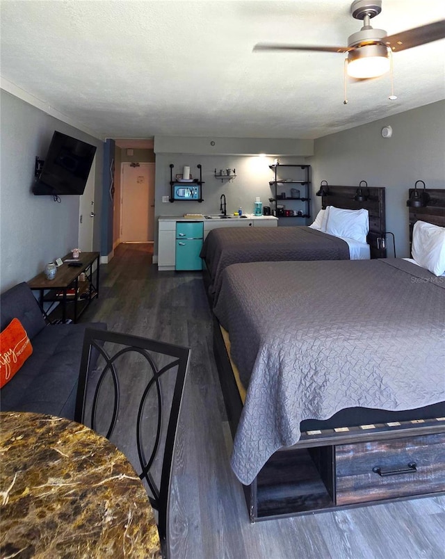 bedroom with dark wood finished floors, a textured ceiling, and ceiling fan