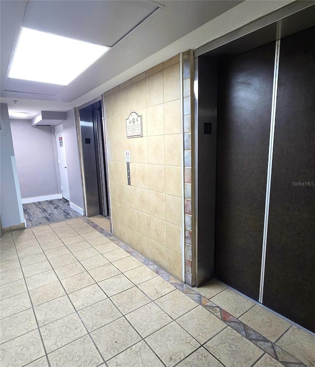 interior space featuring elevator and light tile patterned floors