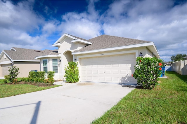 ranch-style house featuring stucco siding, fence, concrete driveway, a front yard, and an attached garage