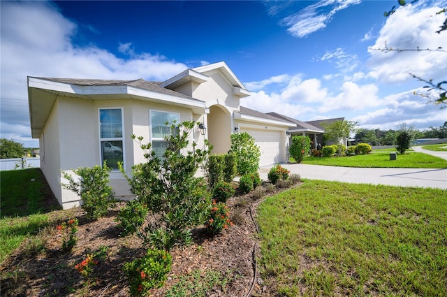 view of side of home with stucco siding, an attached garage, concrete driveway, and a yard