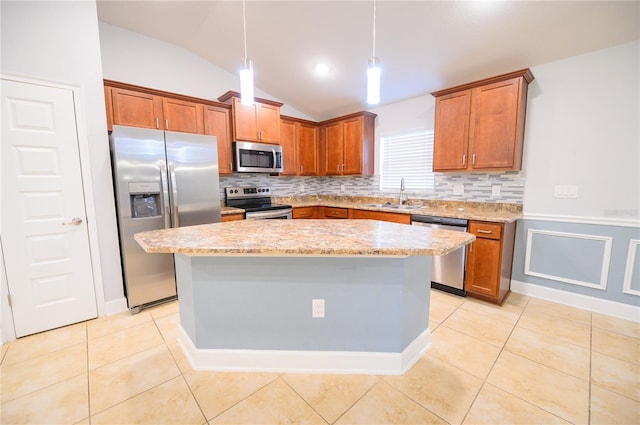 kitchen with light tile patterned floors, appliances with stainless steel finishes, brown cabinetry, and a sink