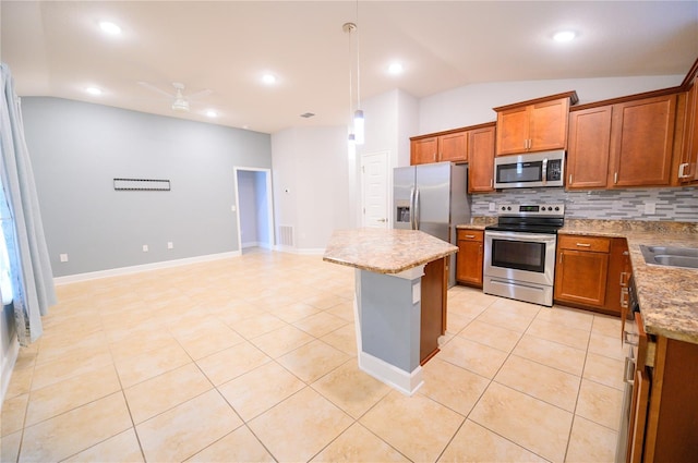 kitchen featuring light tile patterned floors, stainless steel appliances, lofted ceiling, and brown cabinetry