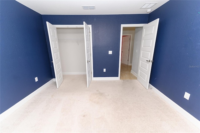 unfurnished bedroom featuring visible vents, baseboards, carpet, and a closet