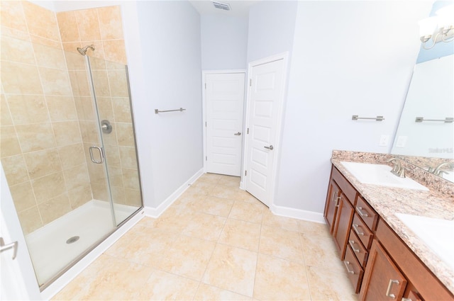 bathroom with tile patterned floors, a sink, a shower stall, double vanity, and baseboards