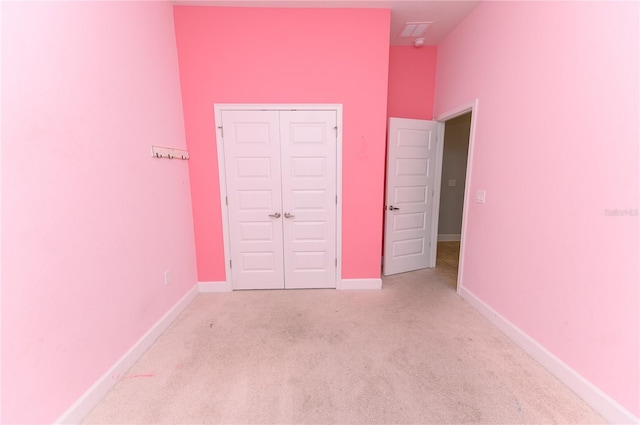 unfurnished bedroom featuring a closet, carpet, and baseboards