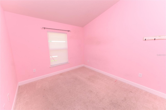 empty room with baseboards, carpet floors, and vaulted ceiling