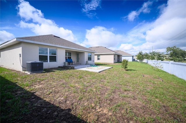 rear view of property featuring central air condition unit, stucco siding, a patio, fence, and a yard