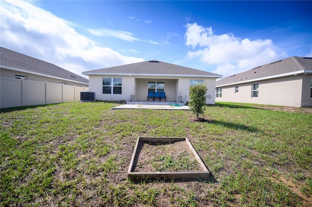 rear view of property featuring a patio, fence, cooling unit, a yard, and a vegetable garden