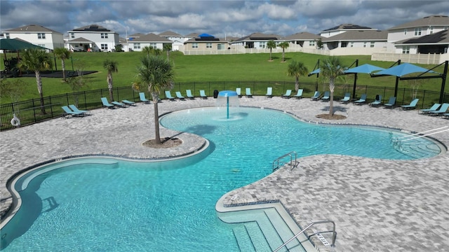 community pool with a residential view, a patio, a yard, and fence