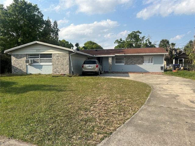 single story home featuring an attached garage, concrete block siding, concrete driveway, and a front lawn