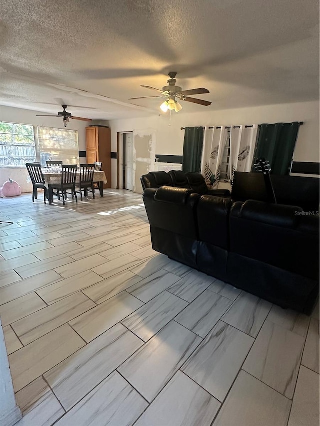 living area featuring a textured ceiling and a ceiling fan