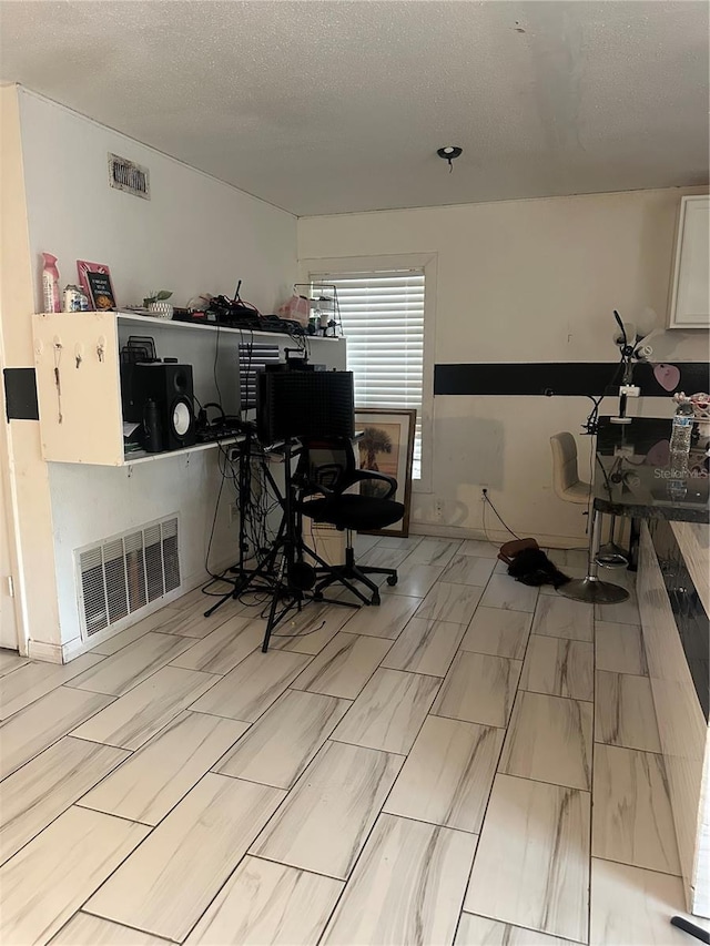 office space featuring visible vents and a textured ceiling